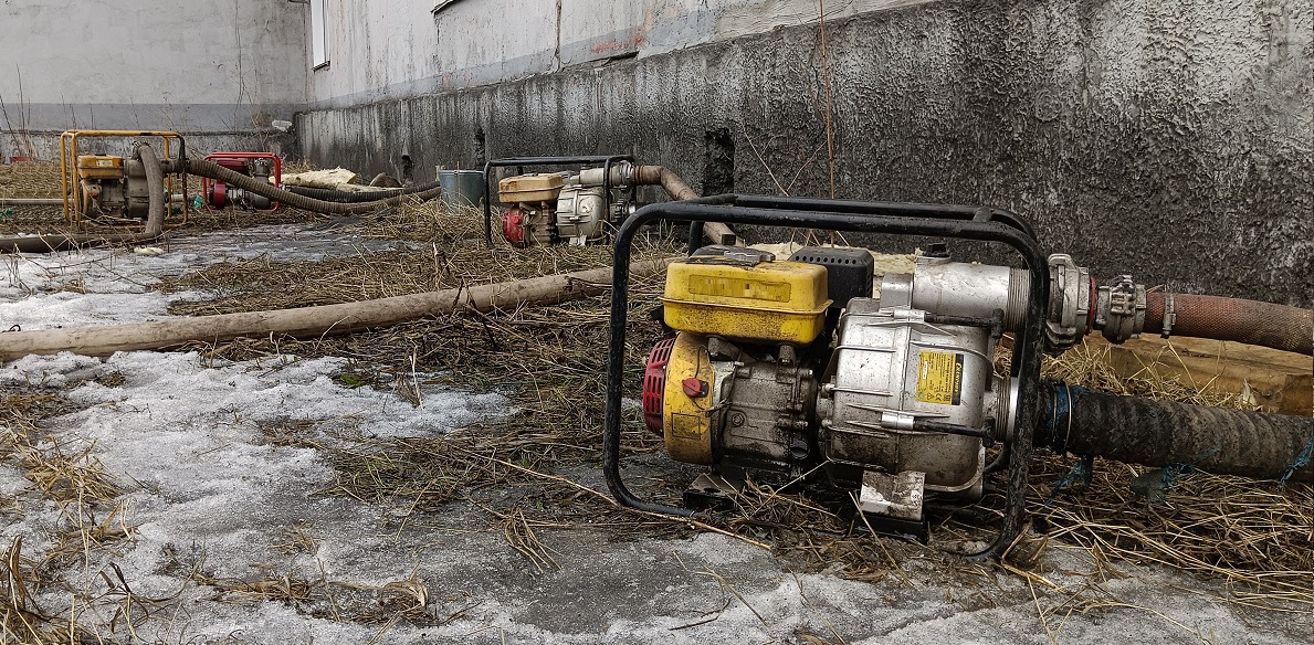 Откачка мотопомпами талой воды из подвала дома в Снежинске